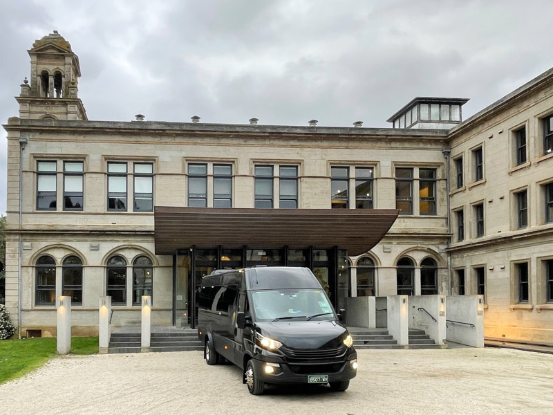 Black minibus dropping passengers at Werribee Mansion