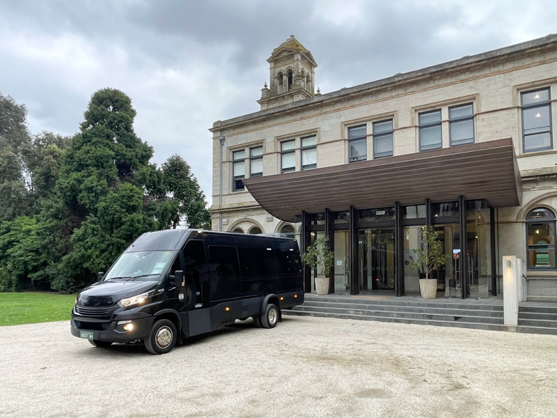 Black minibus dropping passengers at Werribee Mansion